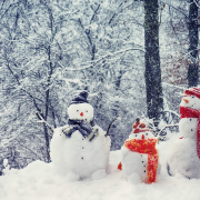 Drei Schneemänner mit Schal im Winter